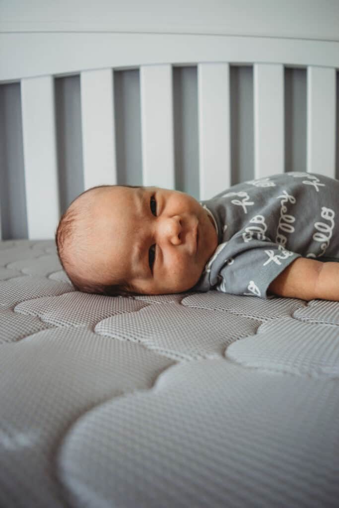 Baby lying on back in crib