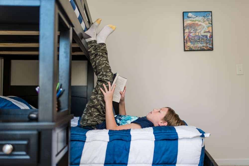 boy reading a book on bunk beds